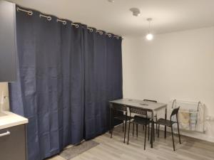 uma sala de jantar com cortinas azuis e uma mesa e cadeiras em Cosyhome em Wellingborough