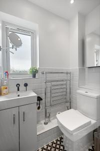 a white bathroom with a toilet and a sink at Tranquil 1 Bed Flat in East London in London