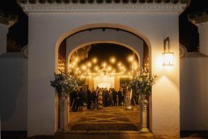 una ceremonia de boda en una habitación iluminada con gente en Hacienda el Burgo, en Mairena del Aljarafe