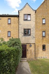 a brick house with a door and a sidewalk at Tranquil 1 Bed Flat in East London in London