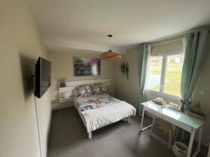 a bedroom with a bed and a desk and a window at Chez Christiane Et Gerard in Orthez