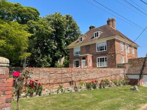 an old brick house with a brick retaining wall at The Manor Pen in Lenham