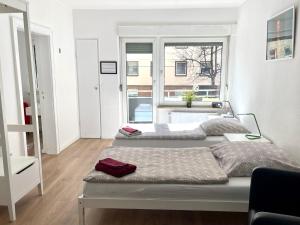 2 Betten in einem Zimmer mit 2 Fenstern in der Unterkunft Messeapartment an der Altstadtmauer in Nürnberg