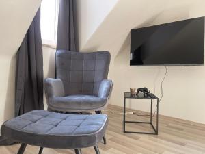 sala de estar con silla y TV en StayEasy Apartments Graz A5, en Graz