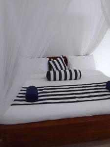 a bed with black and white pillows on it at MALWATHTHA MOUNT VILLA KANDY in Kandy