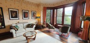uma sala de estar com um sofá e uma mesa em Cader Suite at PenYcoed Hall incl Luxury Hot Tub em Dolgellau