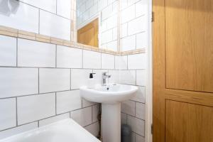 a white bathroom with a sink and a mirror at Redhill Garland- 1 bed ground floor apartment by LGW Short Lets in Redhill