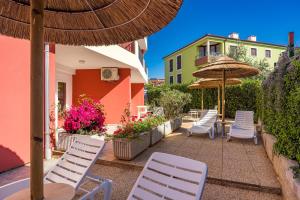 a group of chairs and umbrellas on a patio at Residence Kamenjak in Premantura