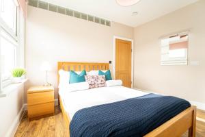a bedroom with a large bed with a blue blanket at Redhill Garland- 1 bed ground floor apartment by LGW Short Lets in Redhill