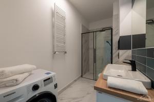 a bathroom with a washing machine next to a sink at Horyzont Apartamenty- Studio- SAUNA&FITNESS -BAŁTYCKA 2- ŚNIADANIA in Kołobrzeg