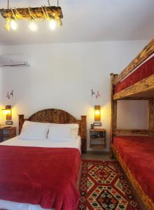 1 dormitorio con cama grande y manta roja en Clockwise GuestRooms en Gjirokastër