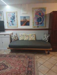 un sofá con almohadas en una habitación en appartamento in villetta il giardino dei semplici, en Bonate di Sopra