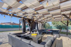 eine Terrasse mit Sofas und einem Tisch unter einer Pergola in der Unterkunft Villa San Paolo in Rovinj