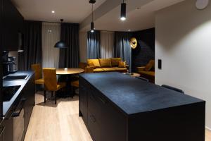 a kitchen and living room with a table and a couch at Royal Roi Apartments in Rovaniemi