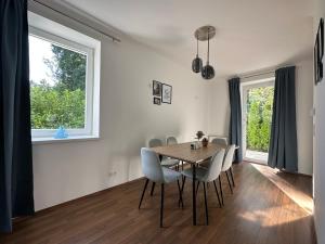 d'une salle à manger avec une table, des chaises et une fenêtre. dans l'établissement FeelHome-GolfClub-Terrasse-6 Gäste-WiFi-Smart TV, à Ebreichsdorf