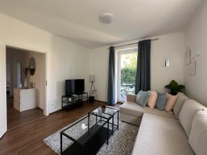 a living room with a couch and a tv at FeelHome-GolfClub-Terrasse-6 Gäste-WiFi-Smart TV in Ebreichsdorf
