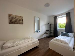 1 dormitorio con 2 camas y ventana en FeelHome-GolfClub-Terrasse-6 Gäste-WiFi-Smart TV, en Ebreichsdorf