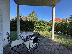 une terrasse couverte avec une table et des chaises. dans l'établissement FeelHome-GolfClub-Terrasse-6 Gäste-WiFi-Smart TV, à Ebreichsdorf