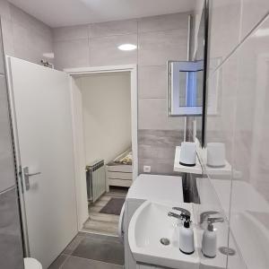 a white bathroom with a sink and a mirror at Pepa Zg in Zagreb