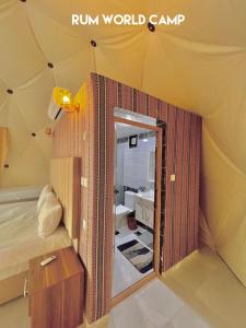 a room with a bed and a mirror in a tent at RUM WORLD BUBBLE lUXURY CAMP in Wadi Rum