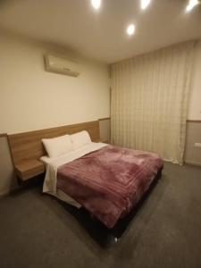 a bedroom with a large bed and a window at Rimini Furnished Apart. in Amman