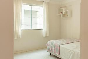1 dormitorio con cama y ventana en 2 quadras do Mar em Meia Praia, Itapema AM2990, en Itapema