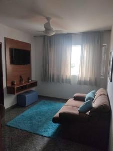 uma sala de estar com um sofá e uma televisão em APT Econômico e Aconchegante 2, Centro-Goiania em Goiânia