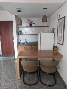 uma cozinha com uma mesa de madeira e um frigorífico em APT Econômico e Aconchegante 2, Centro-Goiania em Goiânia
