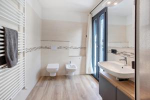 Baño blanco con lavabo y aseo en Panorama Gaudì, en Grosio