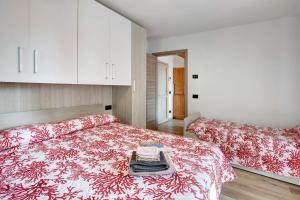 1 dormitorio con 2 camas y mantas rojas y blancas en Panorama Gaudì, en Grosio