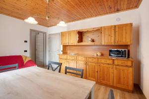 cocina con armarios de madera y mesa con microondas en Panorama Gaudì, en Grosio