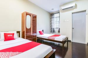 um quarto de hotel com duas camas e um espelho em OYO 89660 Raudhah Inn Hotel em Kampong Bukit Kechil