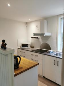 a white kitchen with a sink and a microwave at Håstrups Natur Perle in Fåborg