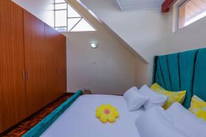 a bedroom with a bed with a flower on it at Cosy and accessible 1BR penthouse with terrace in Nairobi