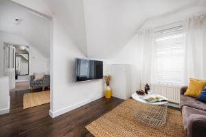 a living room with a couch and a tv on a wall at Bijoux Central Plymouth 1 Bedroom Apartment - Sleeps 5 - Habita Property in Plymouth