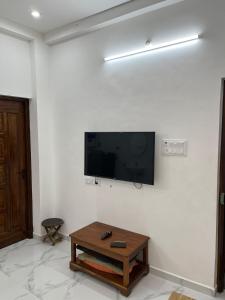 uma sala de estar com uma televisão de ecrã plano na parede em Tree shadow Guest house nearby Beach em Mahabalipuram