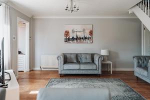 a living room with two chairs and a couch at Stylish spacious home in Redcar in Kirkleatham