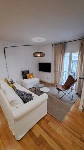 sala de estar con sofá blanco y silla en DreamsApt San Eloy, en Sevilla