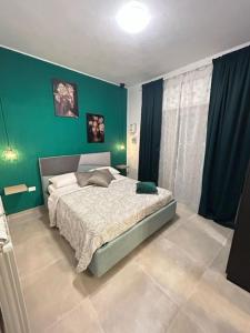 a bedroom with a bed with a green wall at L'antica finestra verde in Marsala