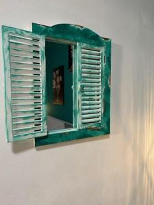 a mirror with an open window on a wall at L'antica finestra verde in Marsala