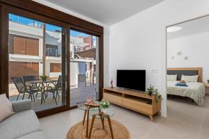 - un salon avec un canapé, une télévision et une table dans l'établissement Luxury Salinas Apartment Flamingo, à San Pedro del Pinatar