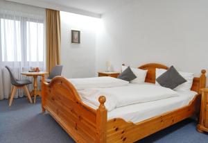 a bedroom with a large wooden bed with white sheets at Alpen Hotel "Villa Bello" in Berchtesgaden +106 photos