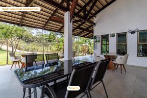 a dining room with a glass table and chairs at Triplex em condomínio de Guaramiranga por Tactu in Guaramiranga
