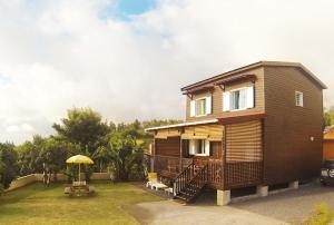 a small house with a porch and an umbrella at Chalet Floricia974, meublé de tourisme in Saint-Paul