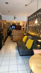 - un salon avec un canapé bleu et des oreillers jaunes dans l'établissement Daiches Braes Brunstane Portobello, à Édimbourg