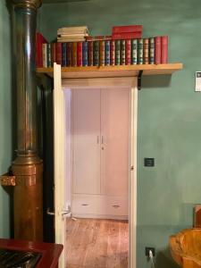 un estante sobre una puerta con libros. en B&B Al Casel, en Tovena