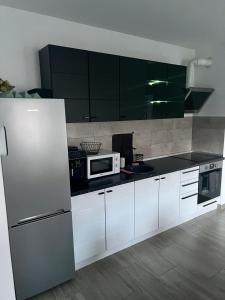 eine Küche mit weißen Schränken und einem weißen Kühlschrank in der Unterkunft Silver House Rasnov in Râșnov