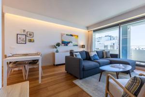 Oasis 28 III by Innkeeper في لشبونة: غرفة معيشة مع أريكة زرقاء وطاولة