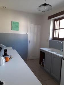 a kitchen with a white counter and a sink at Les guernouilles in Mézières-en-Brenne
