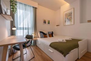 Oasis 28 III by Innkeeper في لشبونة: غرفة نوم بسرير ومكتب ونافذة